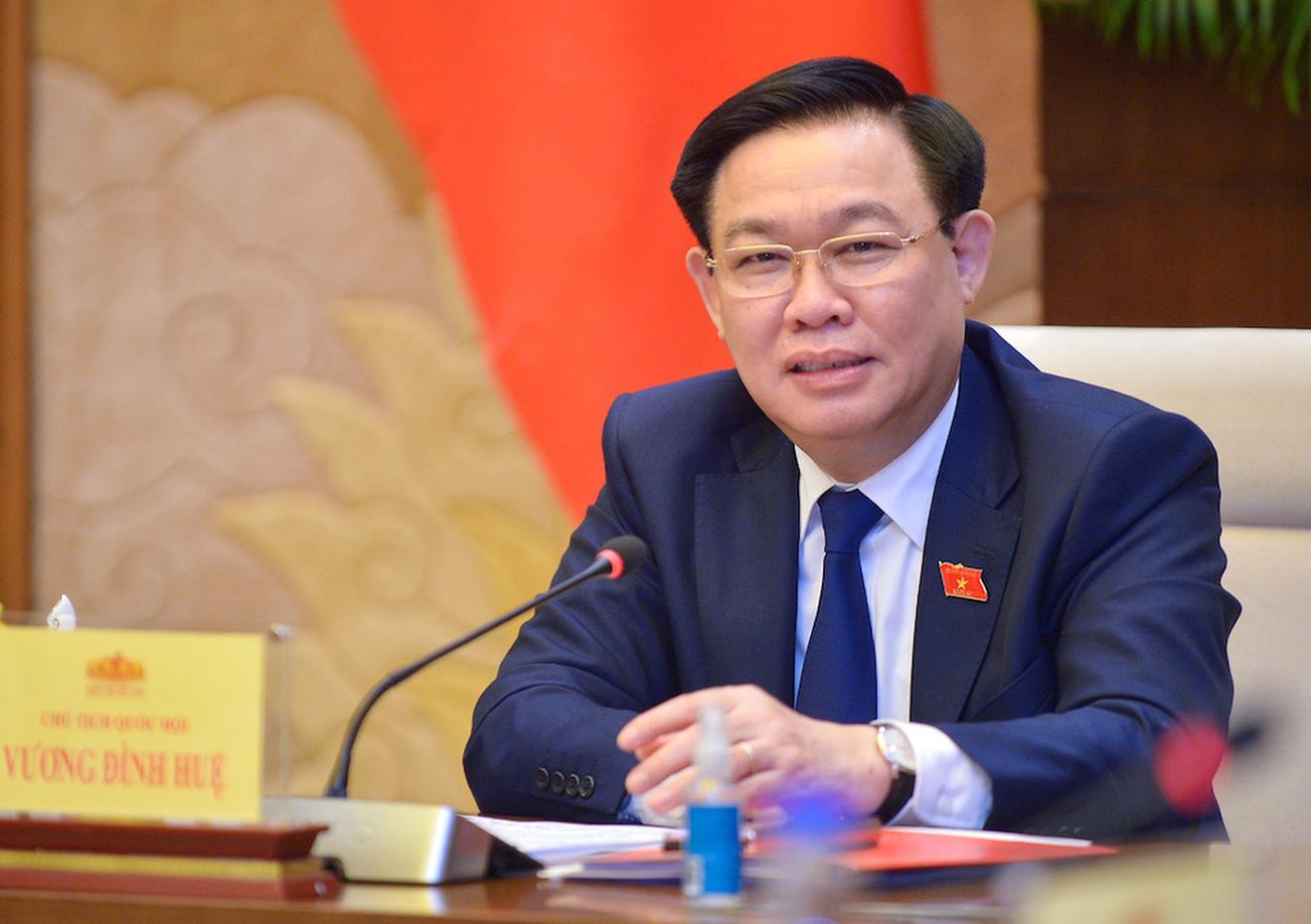 Ông Vương Đình Huệ cài huy hiệu cờ Việt Nam trong hội nghị (Ảnh: P.Thắng)